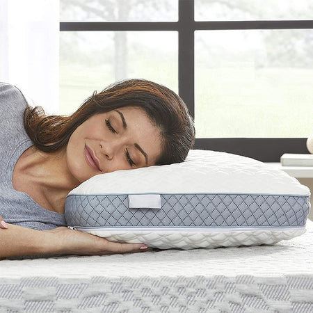 Ein weißes Kopfkissen aus weichem Material auf einem Bett mit einer sauberen weißen Bettwäsche